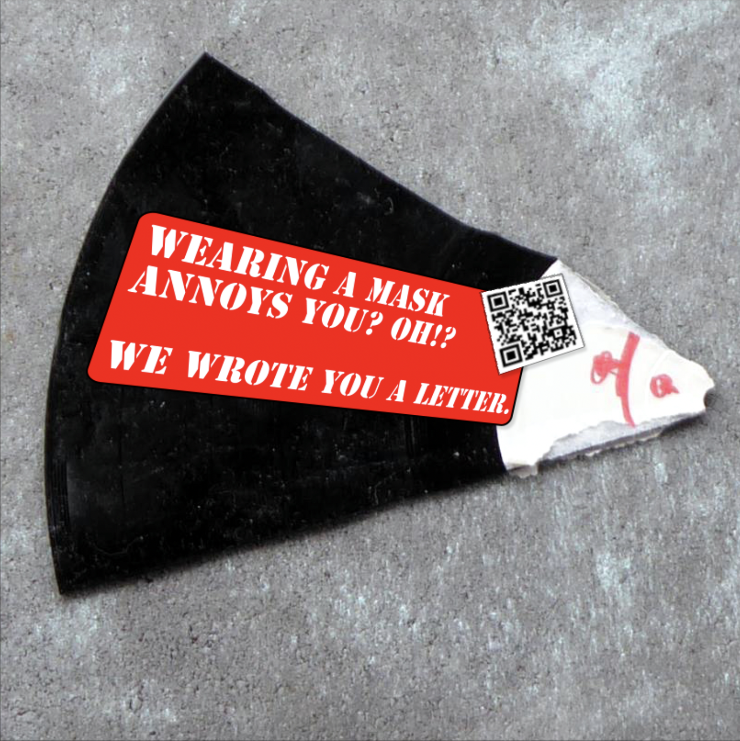 A shard of a record with a sticker on it that reads "Wearing a mask annoys you? Oh?! We wrote you a letter". Next to it there's a QR-code that leads to our zine: An Open Letter to our Comrades
